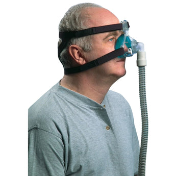 Man wearing a Philips Respironics Profile Lite nasal CPAP mask with black headgear and connected tubing.